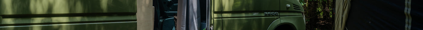image of green mercedes sprinter at a campsite