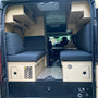 Rear view of a custom 2020 Ram ProMaster 2500 High Roof camper van with handcrafted birch cabinetry, bench seating, upper cabinets, and custom storage by Overland Interiors.