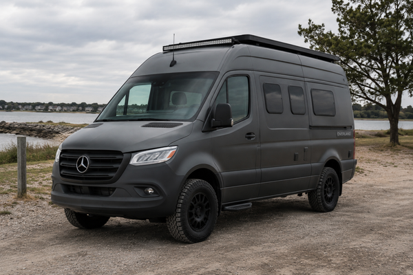Custom Mercedes Sprinter 144 adventure van built by Overland Interiors parked beside a Maryland waterfront, showcasing a modular camper van conversion designed for organized travel and life on the road.