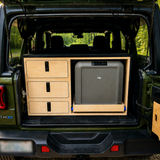 Custom rear storage system in a 2024 Jeep Wrangler 4xe with three secure storage drawers and slide-out Dometic fridge by Overland Interiors