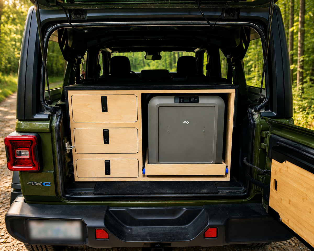 Custom rear storage system in a 2024 Jeep Wrangler 4xe with three secure storage drawers and slide-out Dometic fridge by Overland Interiors