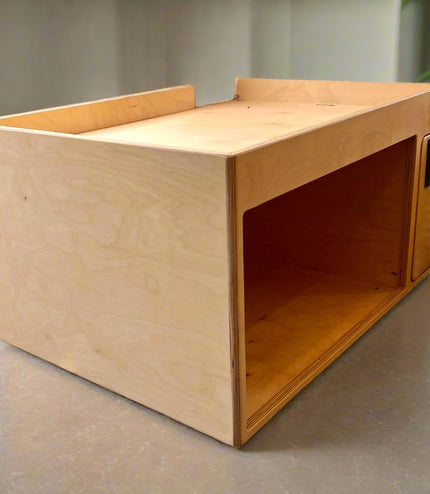 Wooden microwave cabinet on a concrete counter with a plant in the background