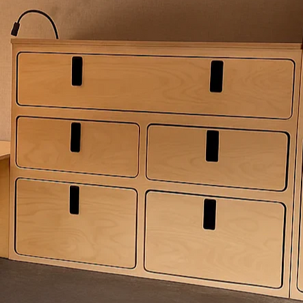 Wooden storage drawers with a metallic surface below in a compact living space.