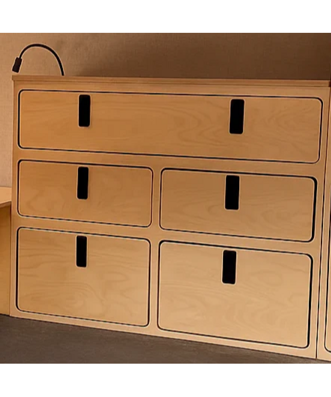 Wooden storage drawers with a metallic surface below in a compact living space.