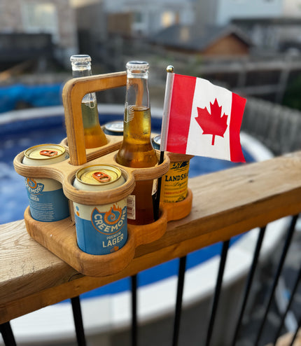 Wooden beer carrier with beer bottles and a Canadian flag on a railing.
