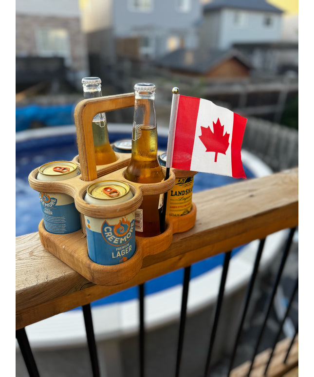 Wooden beer carrier with beer bottles and a Canadian flag on a railing.