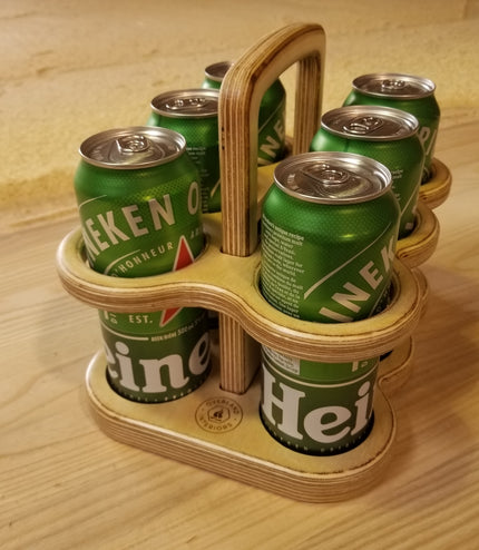 Six-pack holder with Heineken cans on a wooden surface