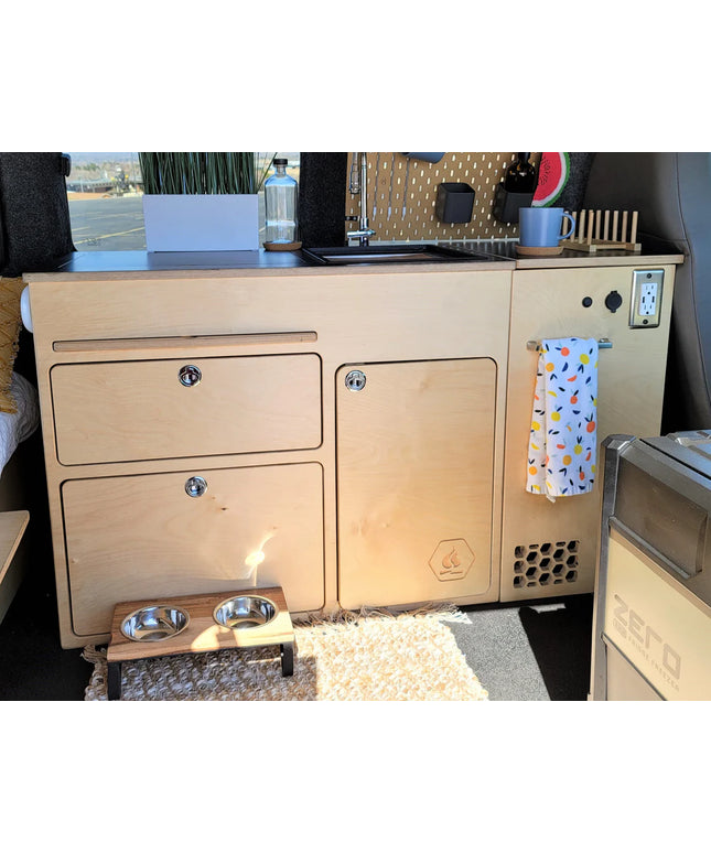 Installed 36-inch kitchen cabinet for high and low roof camper van conversion with integrated storage, countertop, and utility access by Overland Interiors.