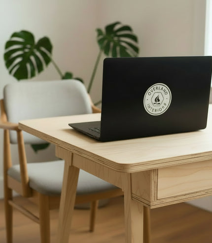 'Overland Interiors' logo sticker on a laptop on a desk