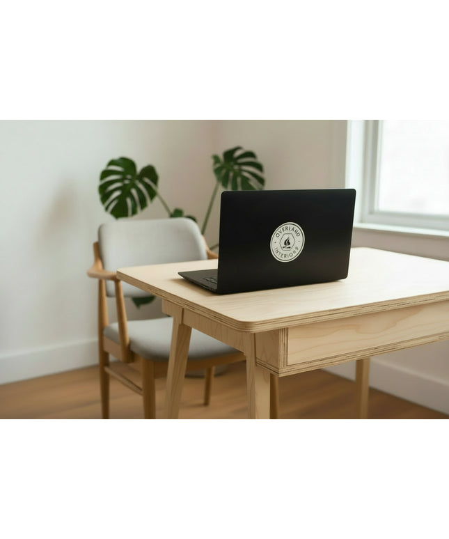 'Overland Interiors' logo sticker on a laptop on a desk