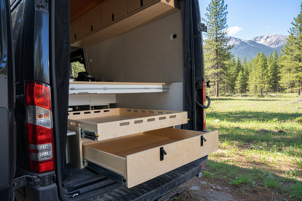 Rear pull-out storage drawer system installed inside a camper van conversion for organized gear and cargo storage by Overland Interiors