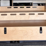 Close-up of a rear pull-out storage drawer and cargo tray system for camper van conversions by Overland Interiors.