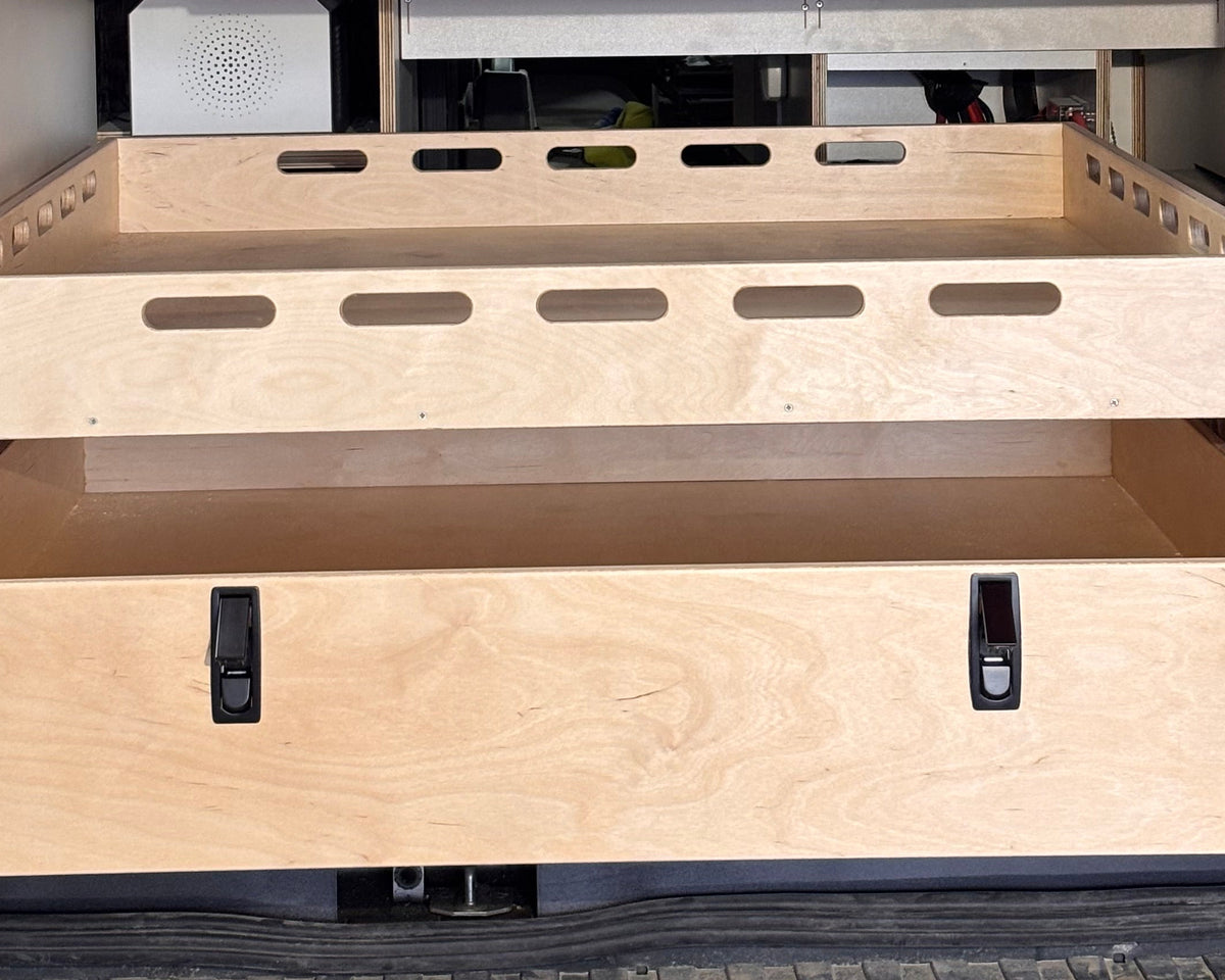 Close-up of a rear pull-out storage drawer and cargo tray system for camper van conversions by Overland Interiors.