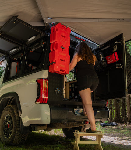 Flat pack camper van step stool in use beside an overland truck camper for easier vehicle access by Overland Interiors