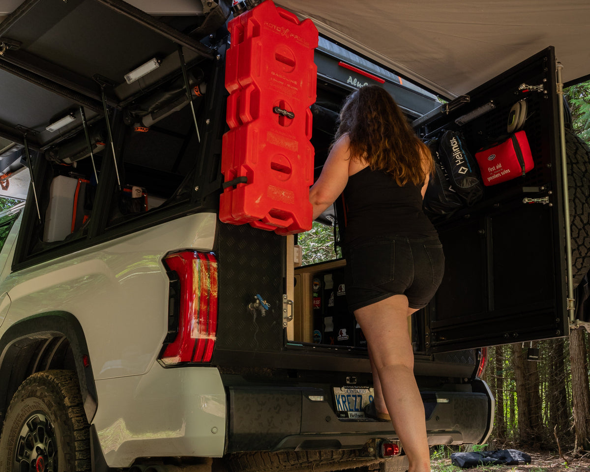 Flat pack camper van step stool in use beside an overland truck camper for easier vehicle access by Overland Interiors
