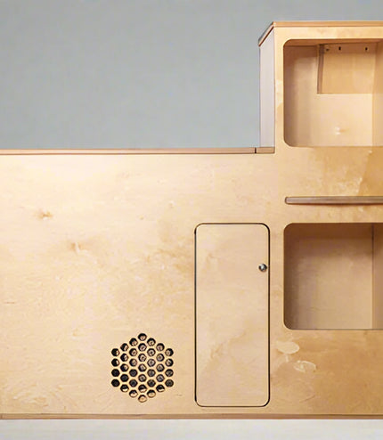 Front view of a compact camper van kitchenette with storage compartments and utility access for van and RV conversions by Overland Interiors