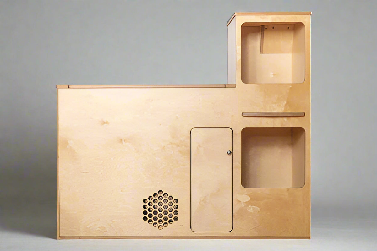 Front view of a compact camper van kitchenette with storage compartments and utility access for van and RV conversions by Overland Interiors