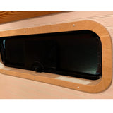Birch interior window trim installed around a CRL AW1033 bunker window in a camper van by Overland Interiors