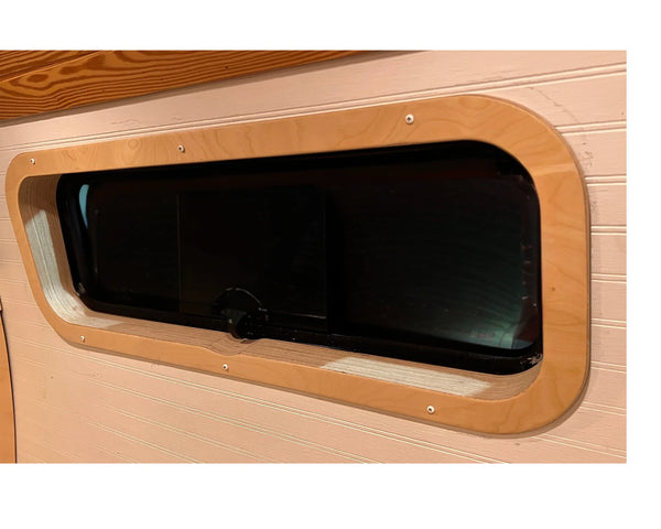 Birch interior window trim installed around a CRL AW1033 bunker window in a camper van by Overland Interiors