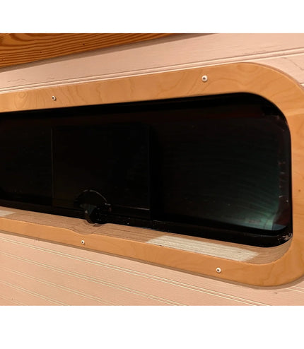 Birch interior window trim installed around a CRL AW1033 bunker window in a camper van by Overland Interiors