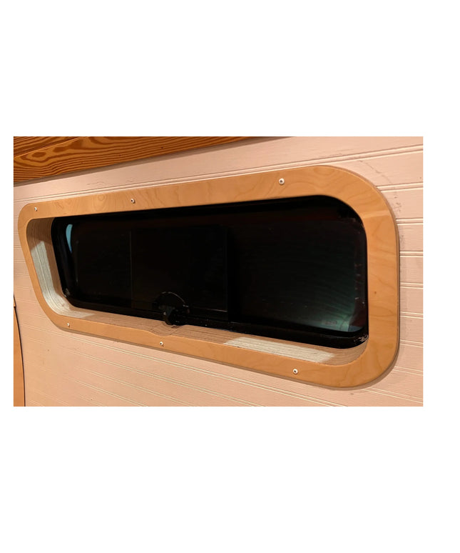 Birch interior window trim installed around a CRL AW1033 bunker window in a camper van by Overland Interiors