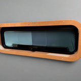 Custom birch interior trim for CR Laurence AW1033 bunk window by Overland Interiors for camper van and overland vehicle conversions.