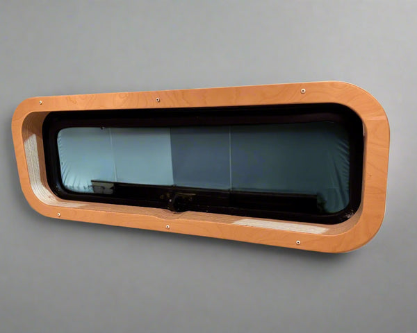 Custom birch interior trim for CR Laurence AW1033 bunk window by Overland Interiors for camper van and overland vehicle conversions.