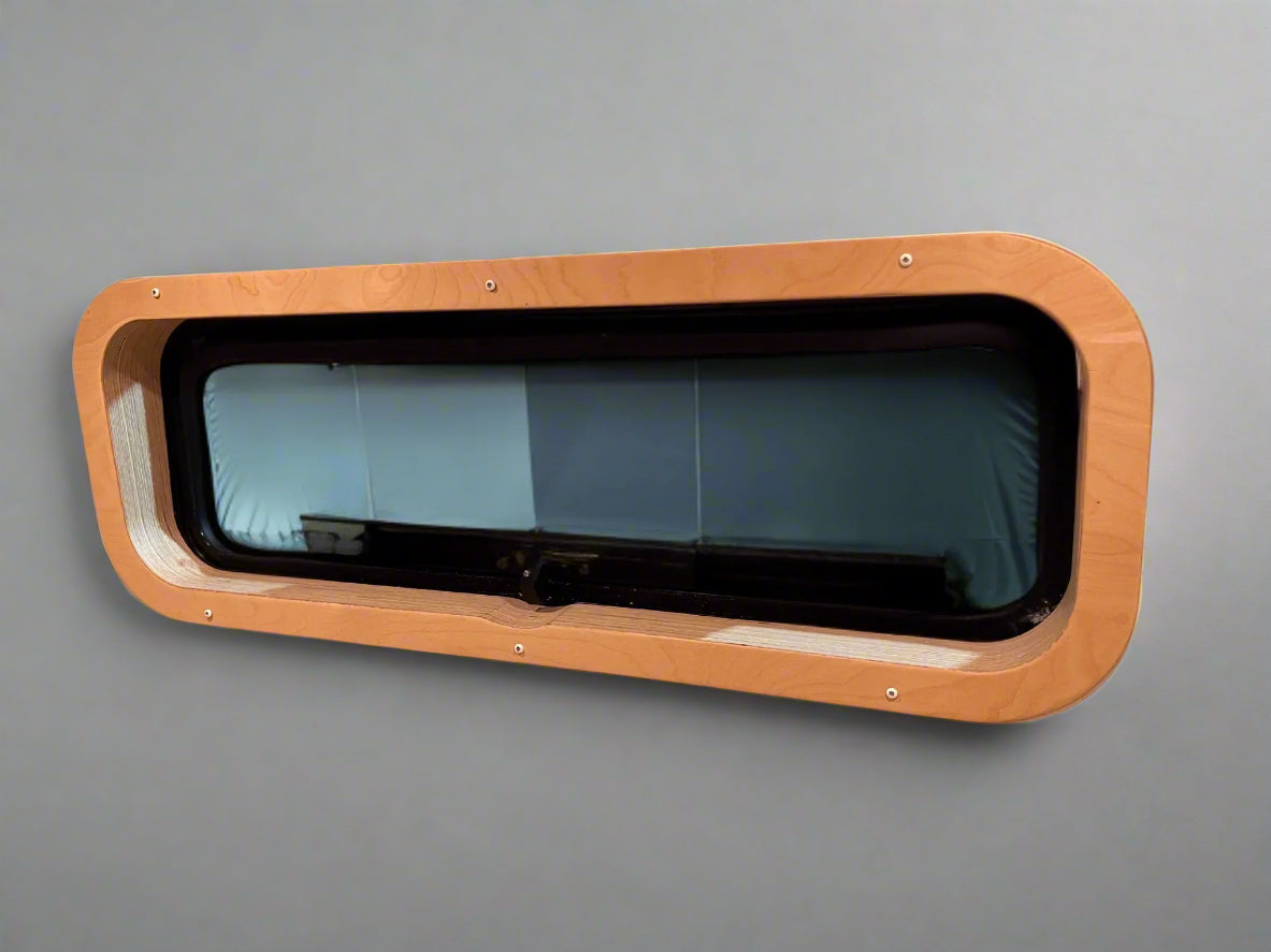 Custom birch interior trim for CR Laurence AW1033 bunk window by Overland Interiors for camper van and overland vehicle conversions.