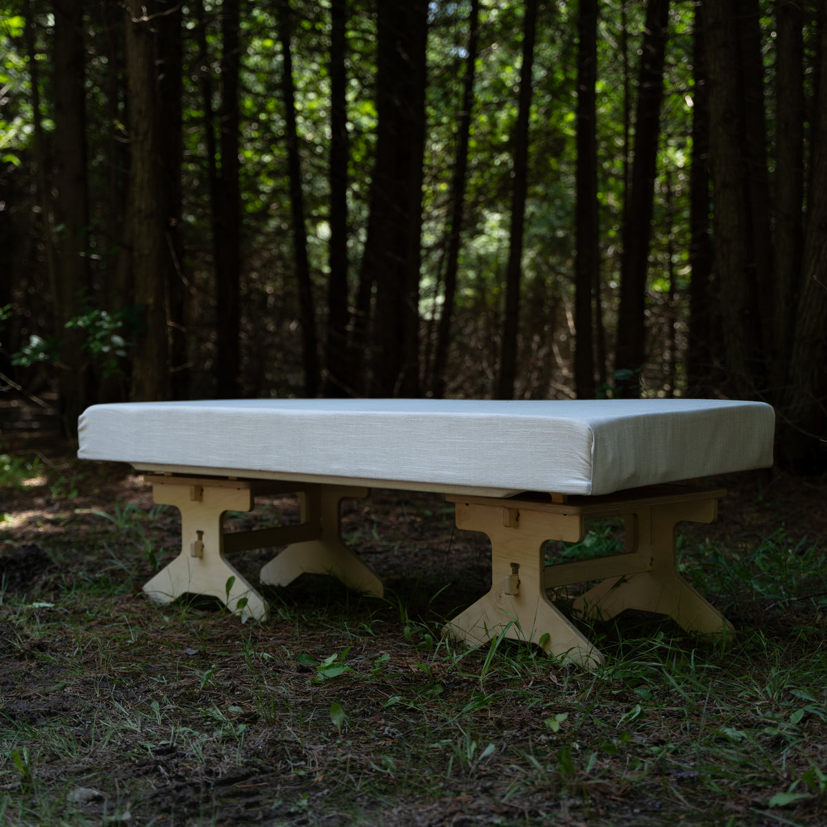 Flat pack camping bench platform assembled with a cushion for outdoor seating by Overland Interiors