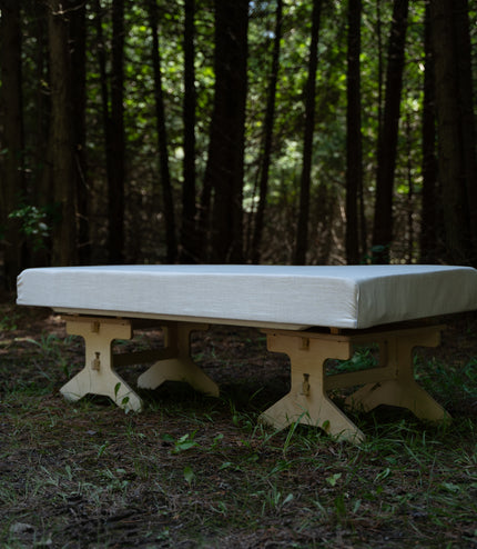 Flat pack camping bench platform assembled with a cushion for outdoor seating by Overland Interiors
