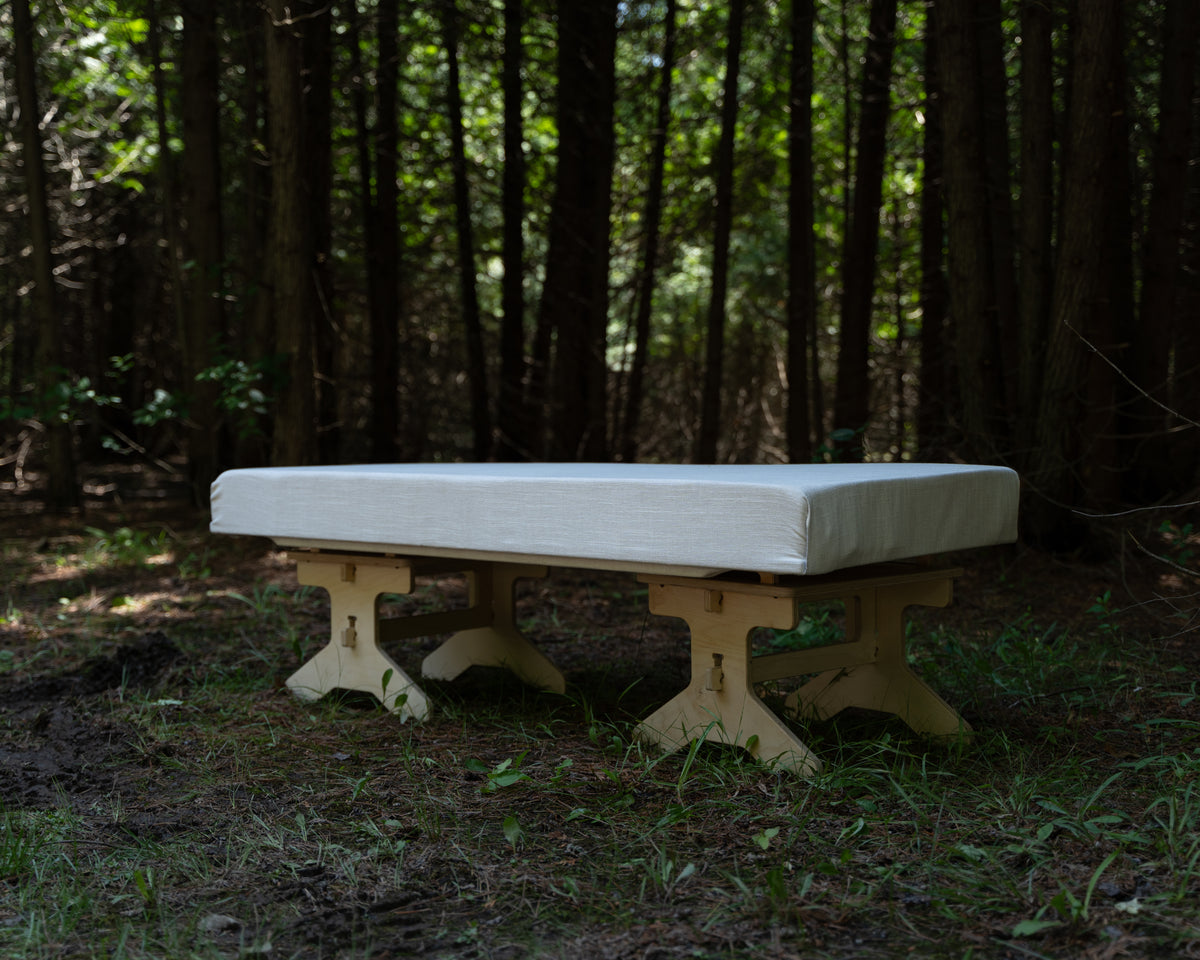 Flat pack camping bench platform assembled with a cushion for outdoor seating by Overland Interiors