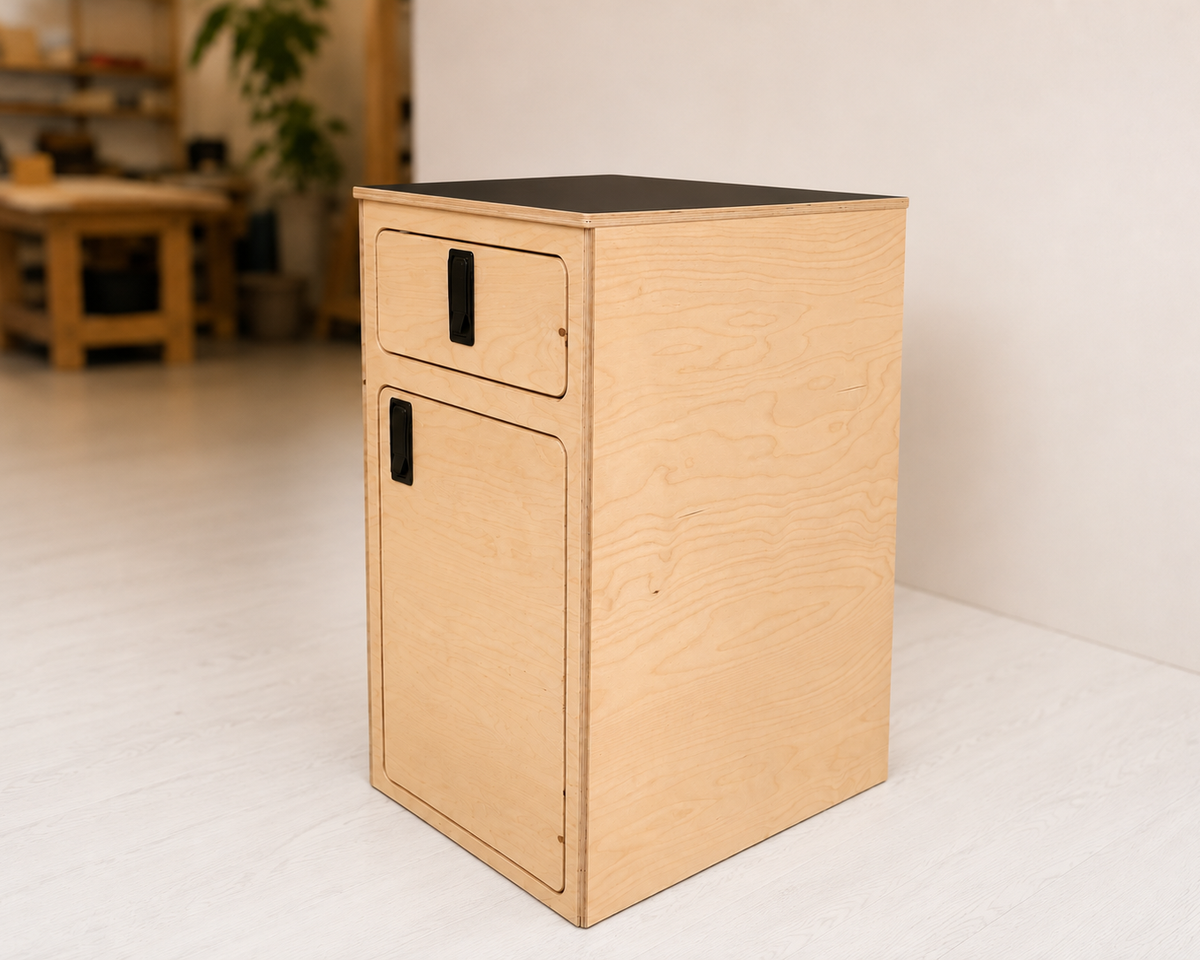Overland Interiors One+One Base Cabinet in birch plywood with black laminate countertop, shown from the side.