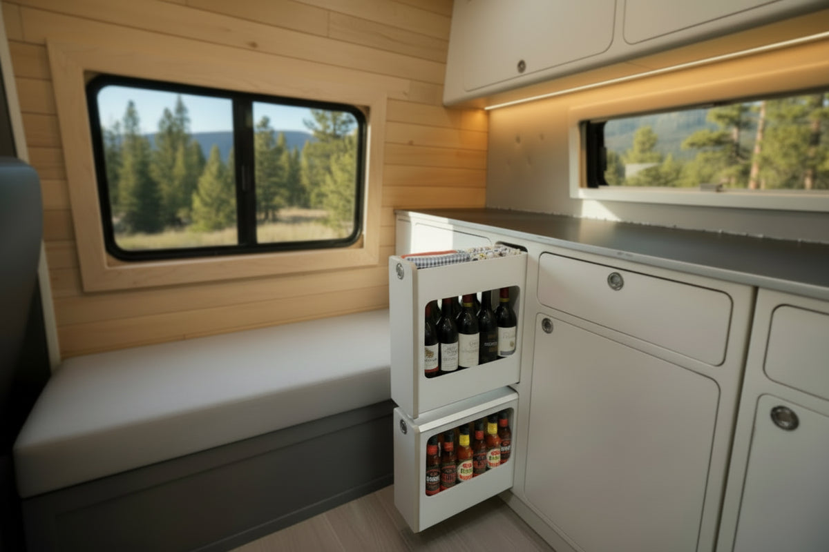 Slim insert cabinet with pull-out narrow storage drawers installed inside a camper van kitchen and storage system by Overland Interiors