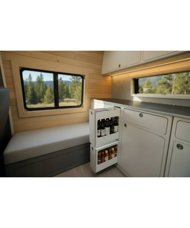 Slim insert cabinet with pull-out narrow storage drawers installed inside a camper van kitchen and storage system by Overland Interiors
