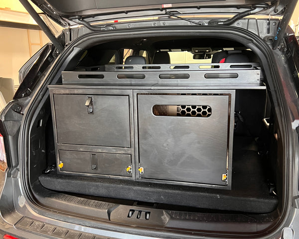 Overland Interiors Trail Series rear kitchen and storage system installed in a Ford Explorer, featuring secure storage cabinets, a pull-out kitchen module, and durable cabinetry for camping and overland travel.
