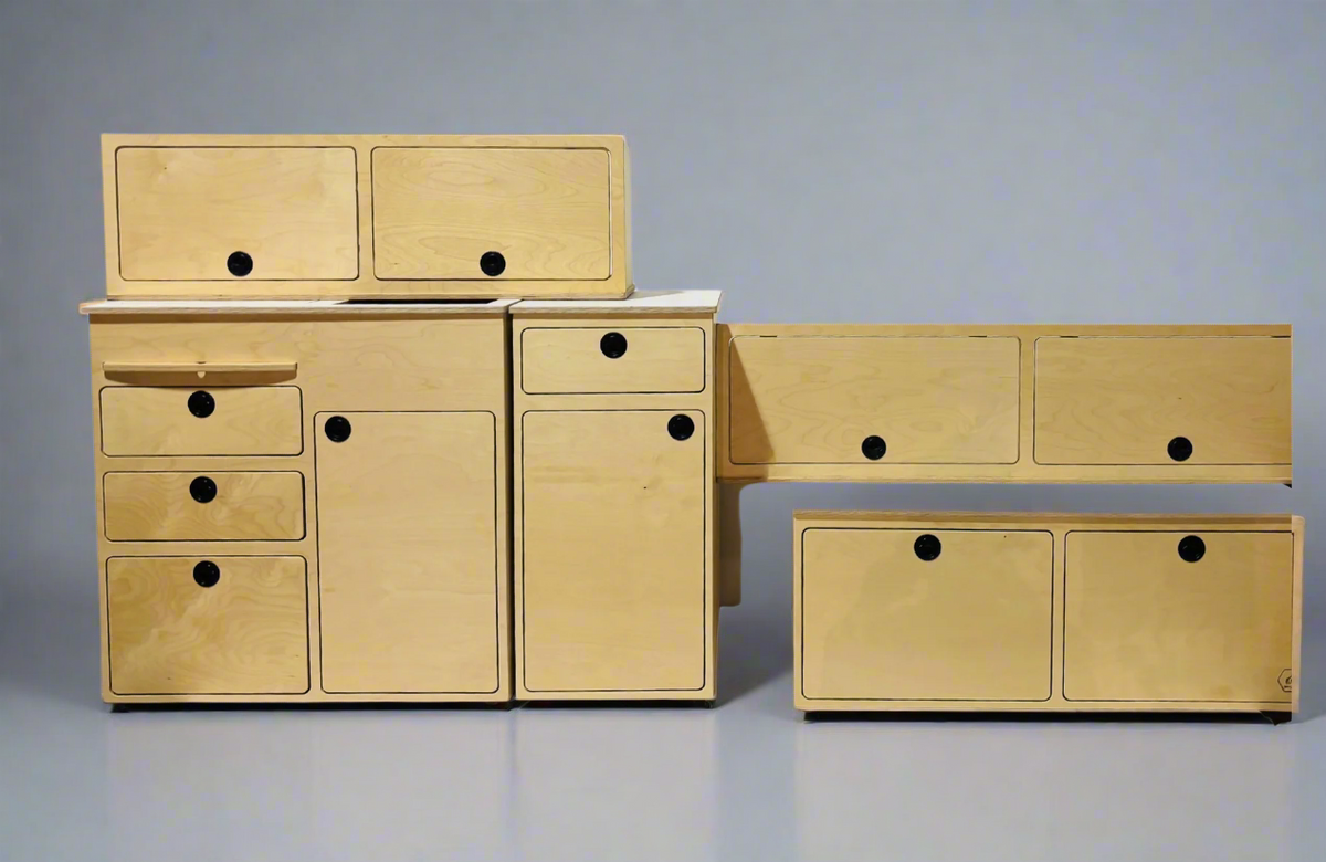 Modular Ford Transit camper van conversion kit components including cabinetry, storage, and interior furniture by Overland Interiors.