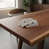 Overland Interiors van life and overland vinyl sticker pack displayed on a walnut dining table.