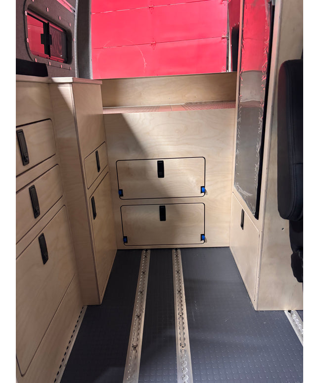 Van bed platform cover panel with integrated storage access doors in camper van
